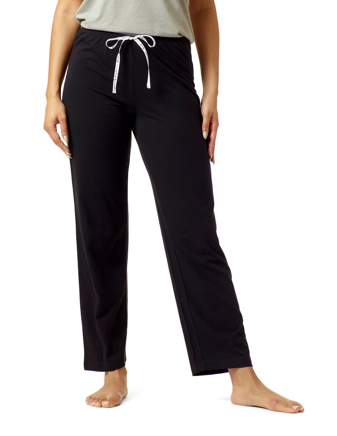 Woman wearing black pj pants on white backgrounhd