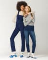 Denim jeans paired with Liflat shoes.  Model positioned in front of produce stand with oranges, mangoes and lemons.