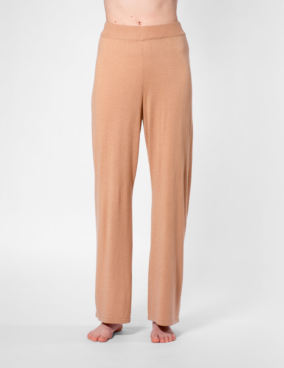 Tan pants worn by a person on a white background