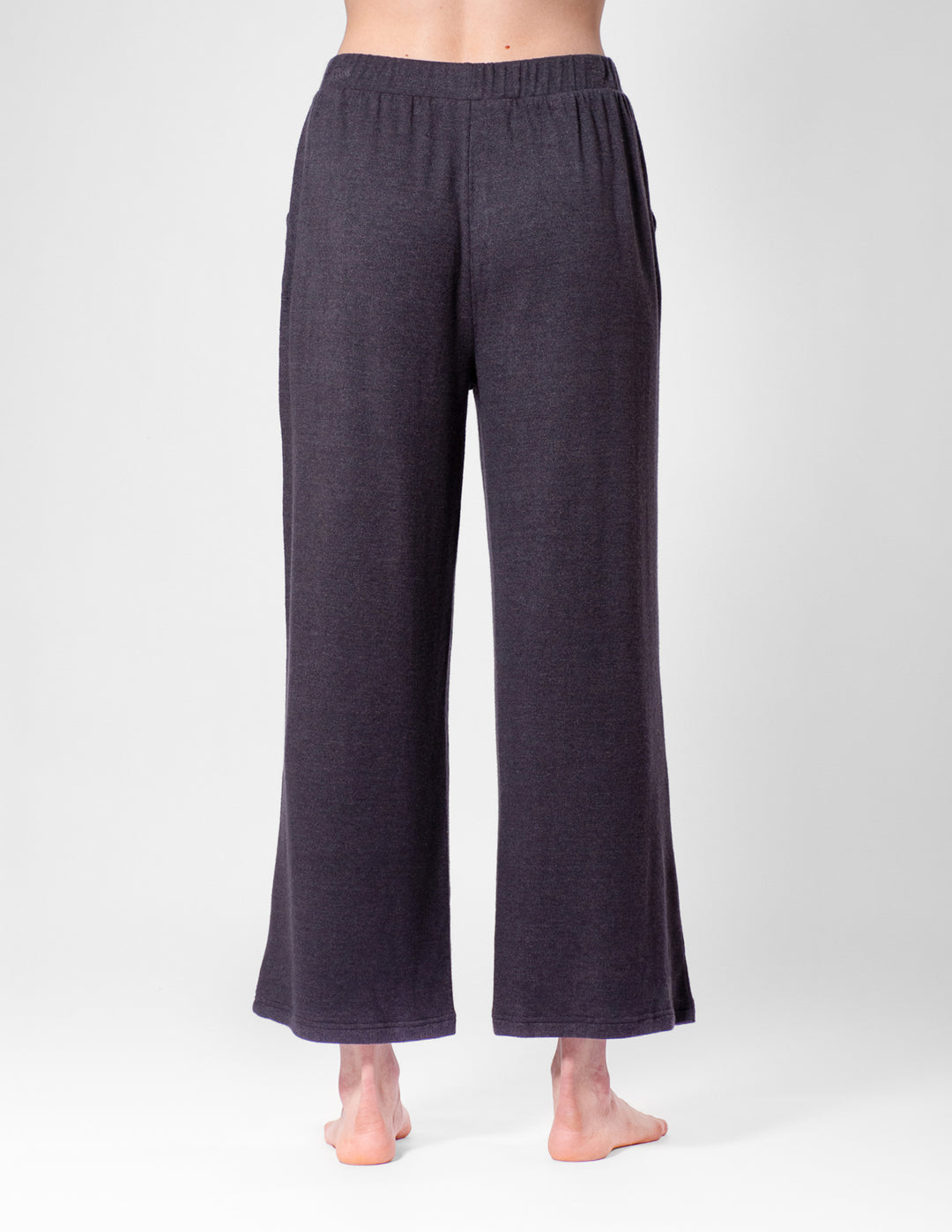 Dark grey wide-leg pants worn by a person on a white background