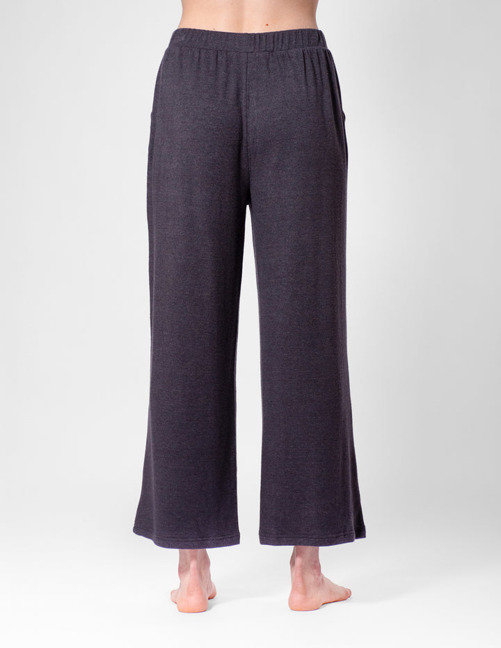 Dark grey wide-leg pants worn by a person on a white background