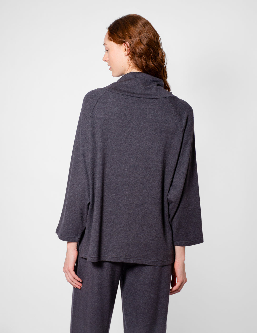 Person wearing a gray outfit on a plain background