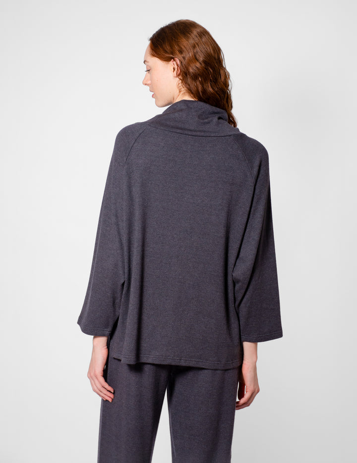 Person wearing a gray outfit on a plain background