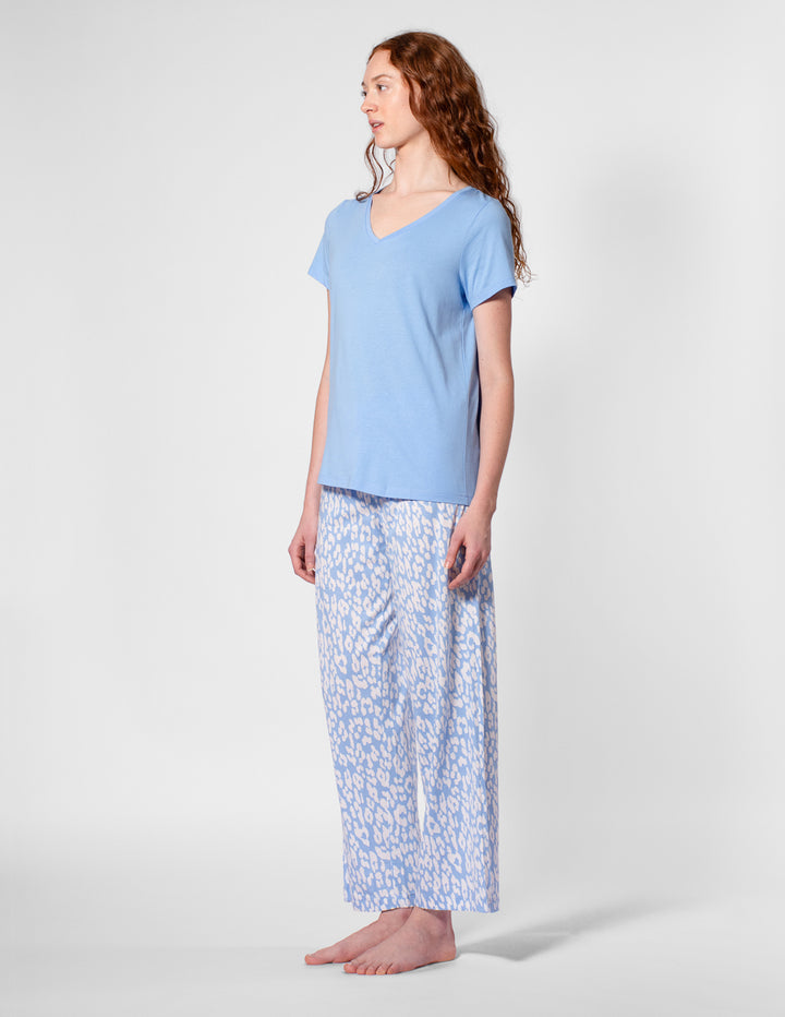 Woman wearing a light blue pajama set with a white background