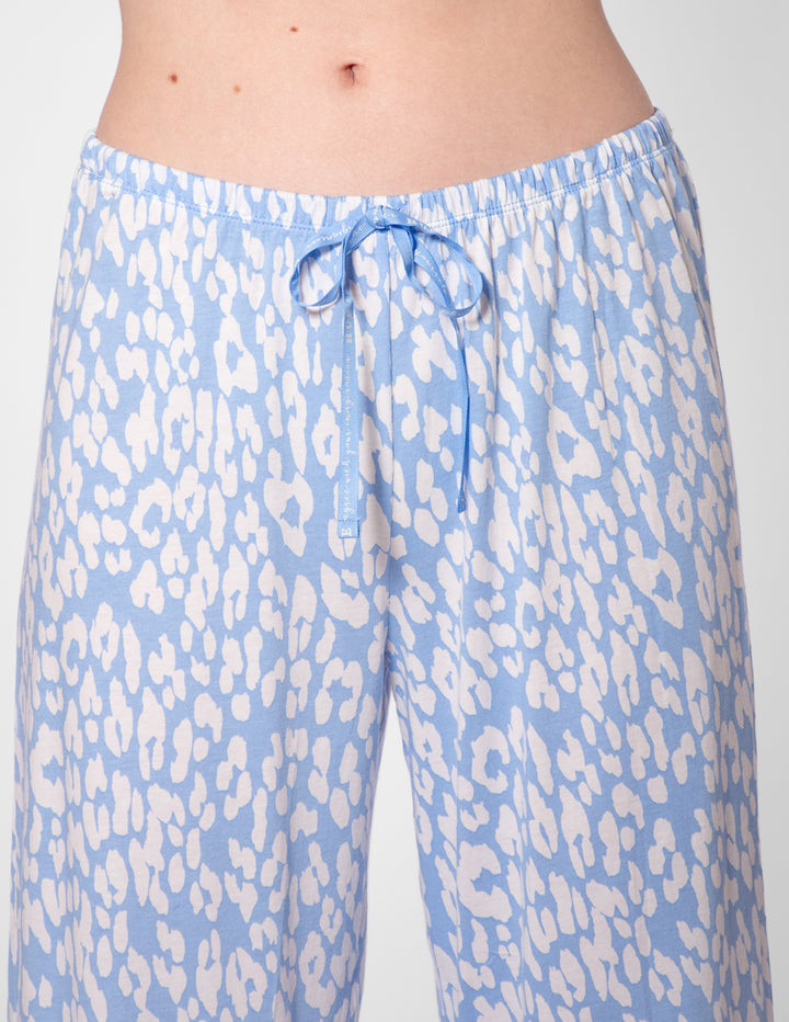 Light blue pajama pants with white animal print pattern on a plain background