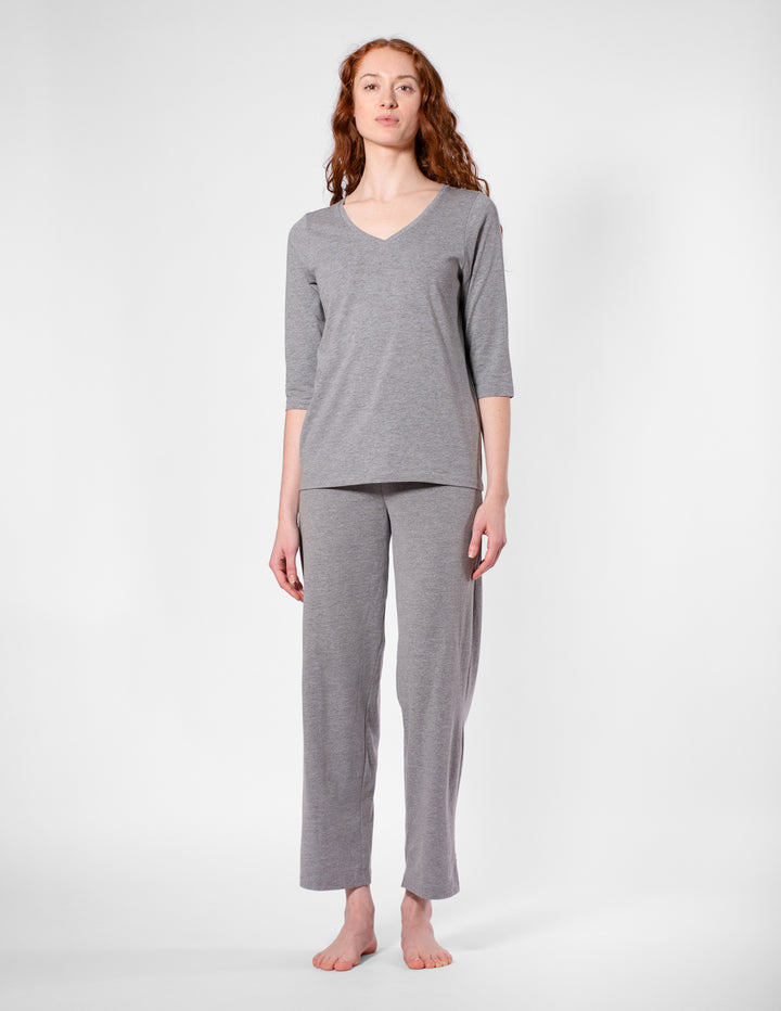 Woman wearing a gray pajama set on a white background