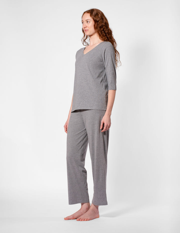 Woman wearing a gray pajama set on a white background