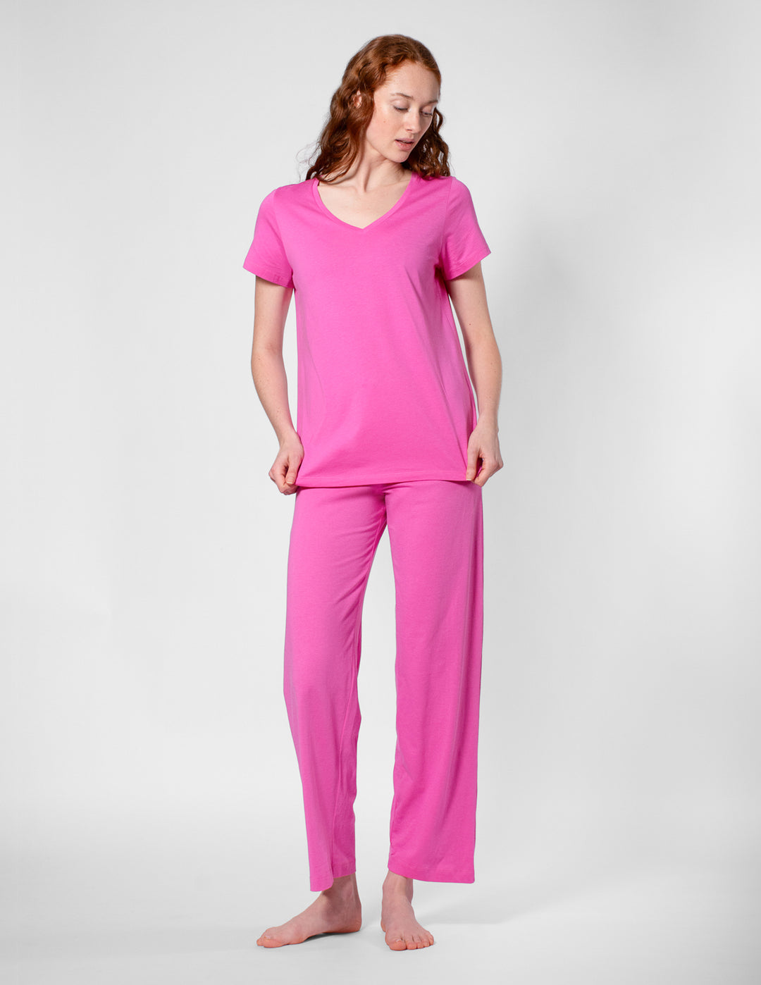 Woman wearing a pink pajama set on a white background