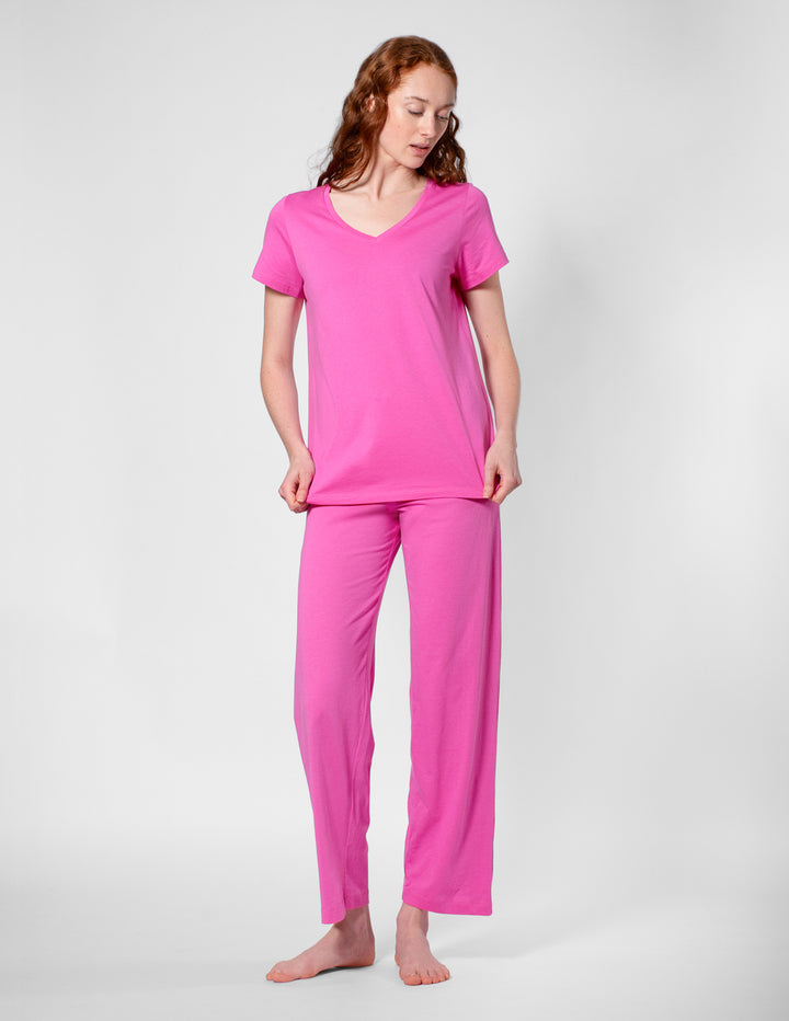 Woman wearing a pink pajama set on a white background