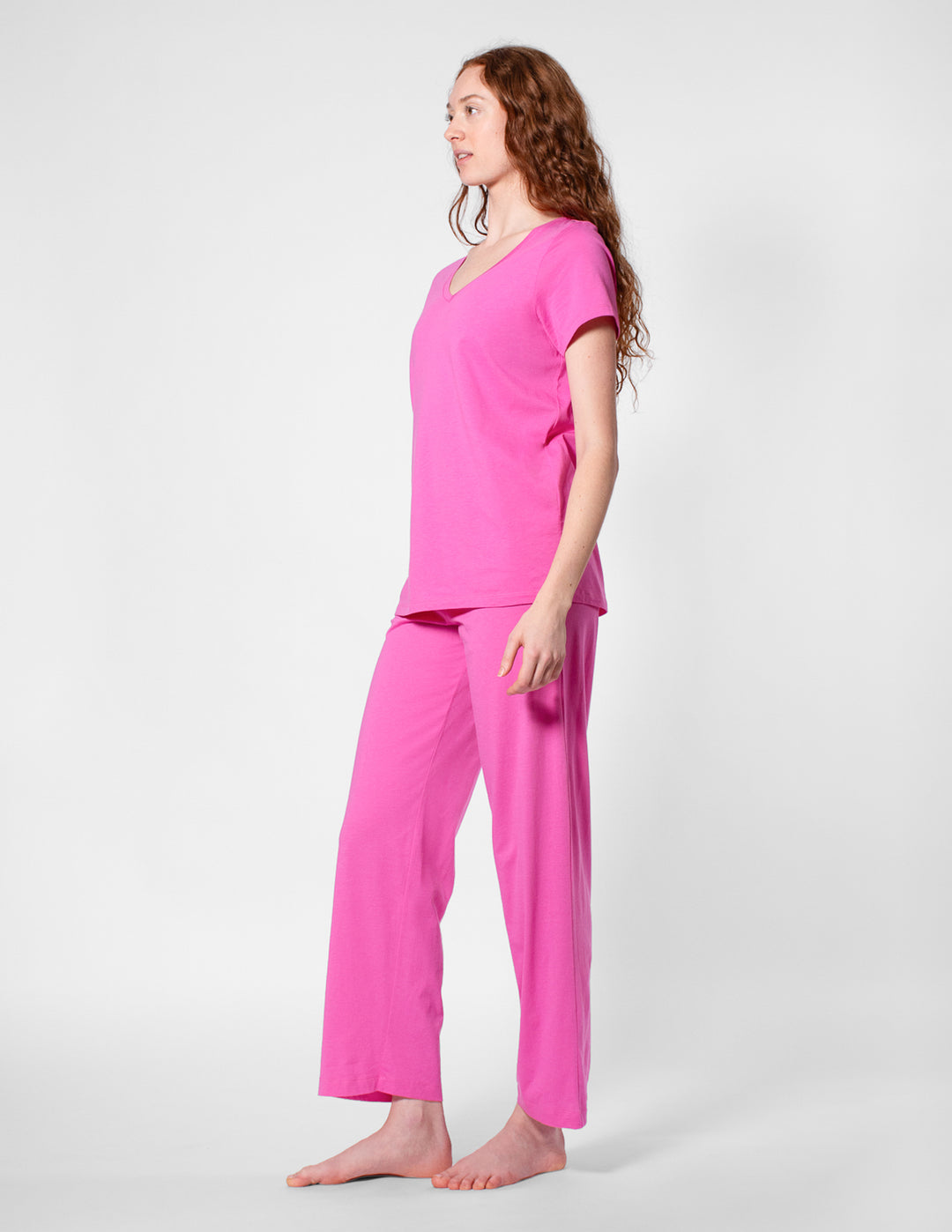 Woman wearing a pink pajama set on a white background