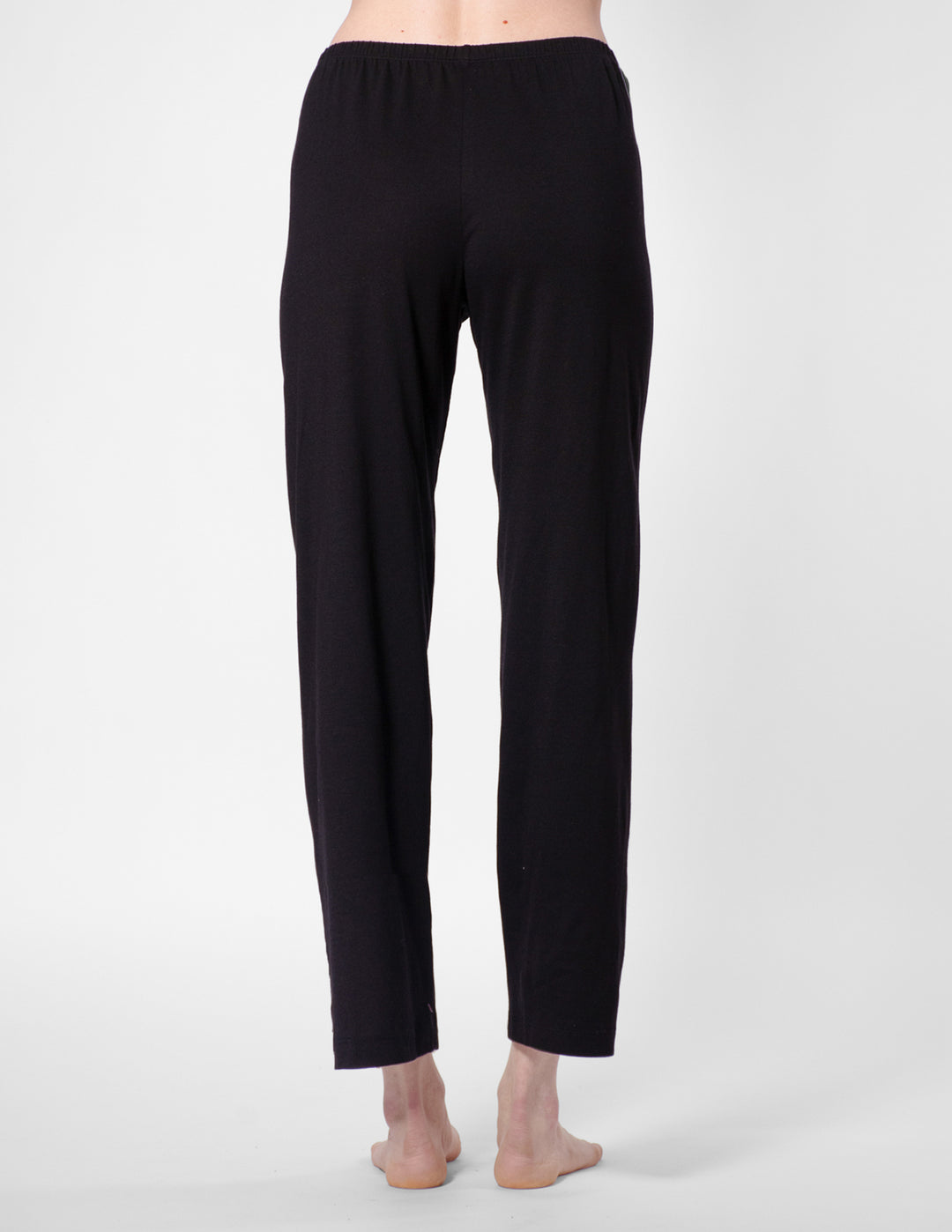 Black pants worn by a person on a white background