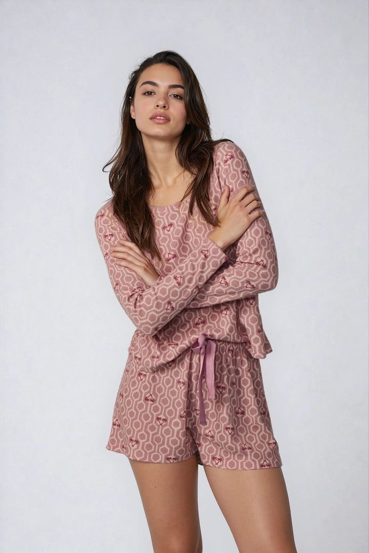 Woman wearing a pink patterned outfit on a white background