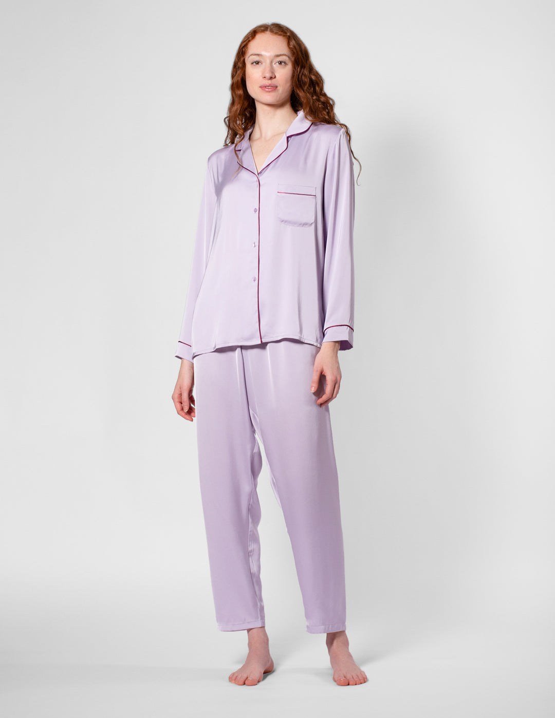 Woman wearing a lavender pajama set against a white background