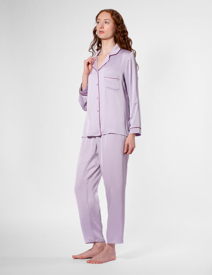 Woman wearing a lavender pajama set on a white background