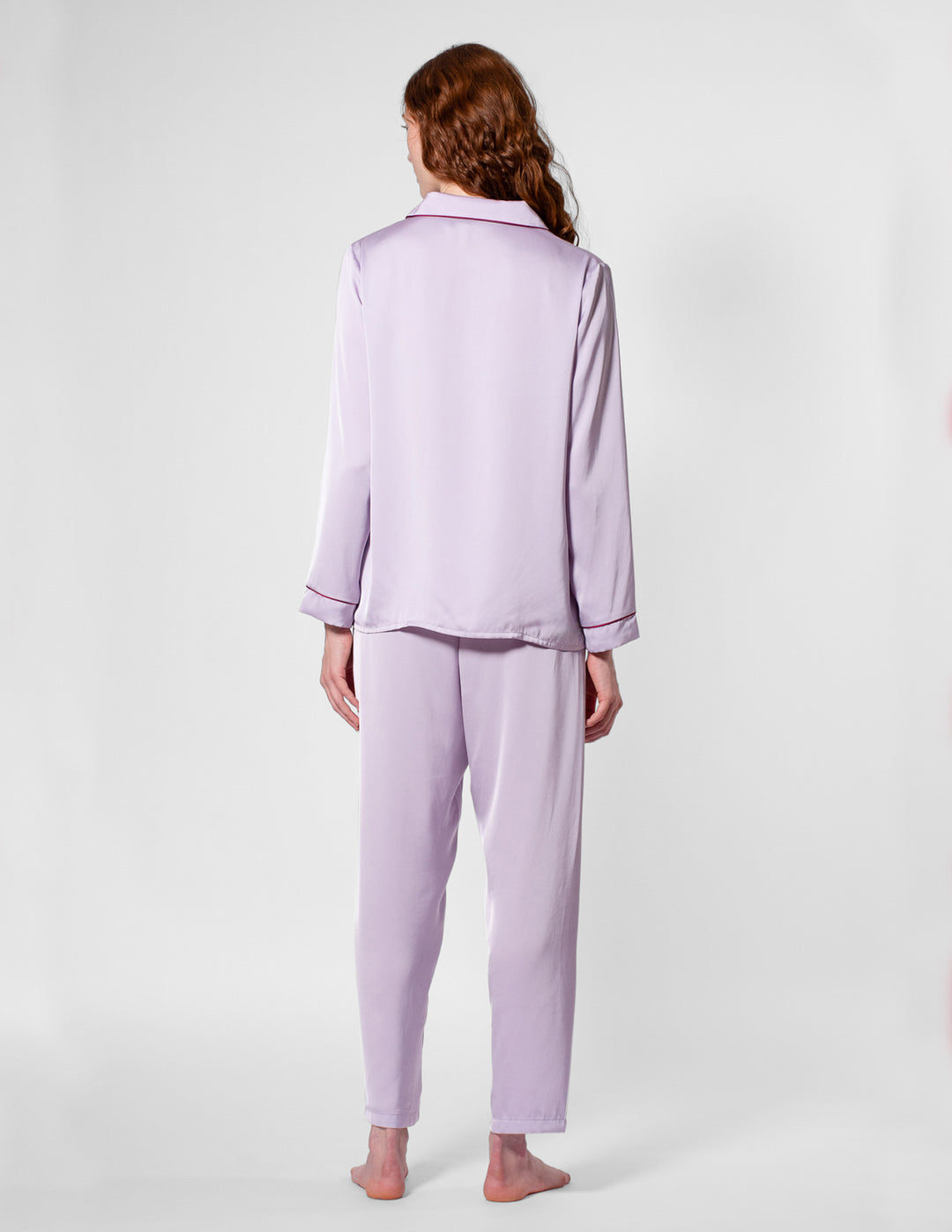 Person wearing a light purple pajama set on a white background