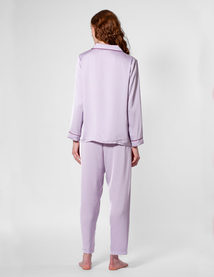 Person wearing a light purple pajama set on a white background
