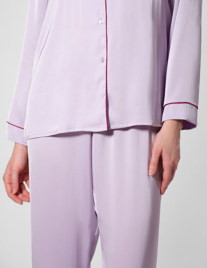 Light purple pajama set with red piping on a light gray background