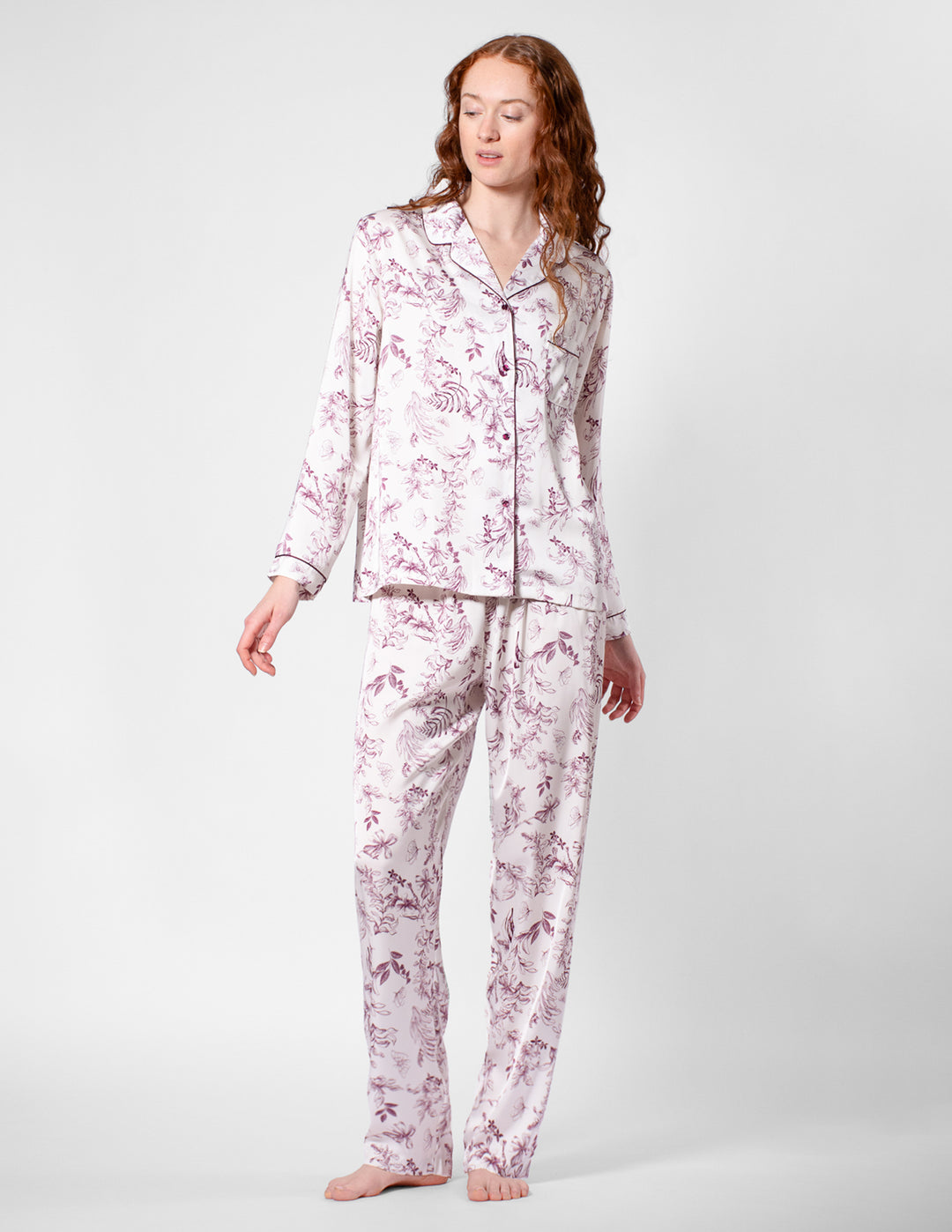 Woman wearing a pink floral pajama set on a white background
