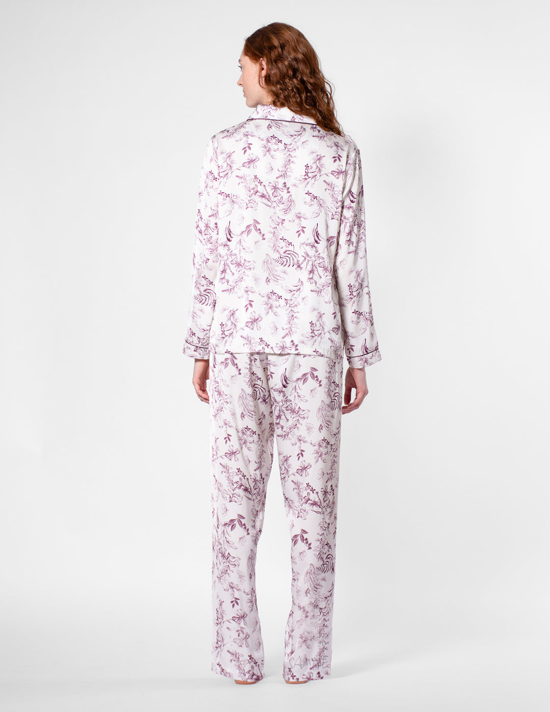 Person wearing a floral pajama set on a white background
