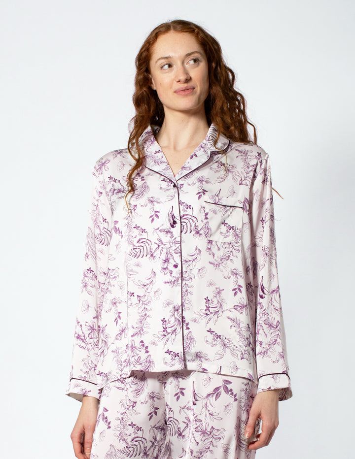 Woman wearing a floral pajama set on a white background