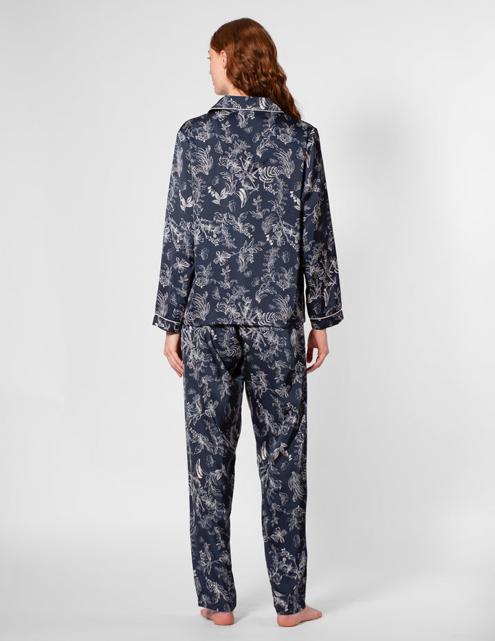 Person wearing navy floral pajamas on a white background