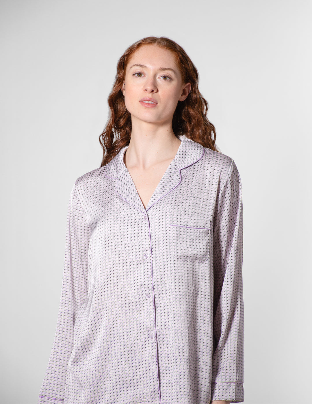 Woman wearing a patterned shirt against a plain background
