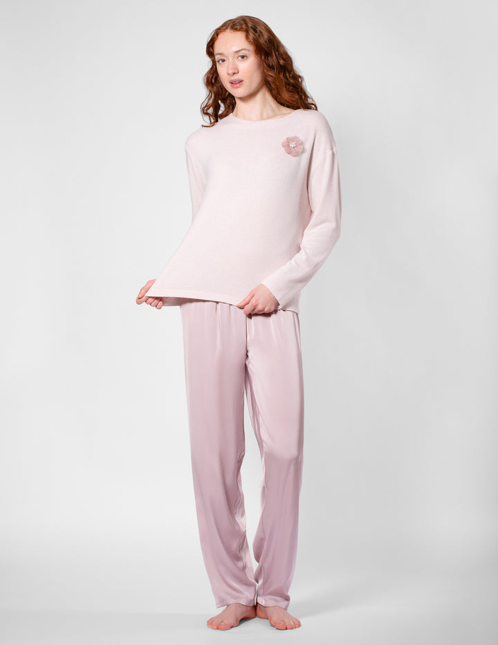 Woman wearing a pink pajama set on a white background