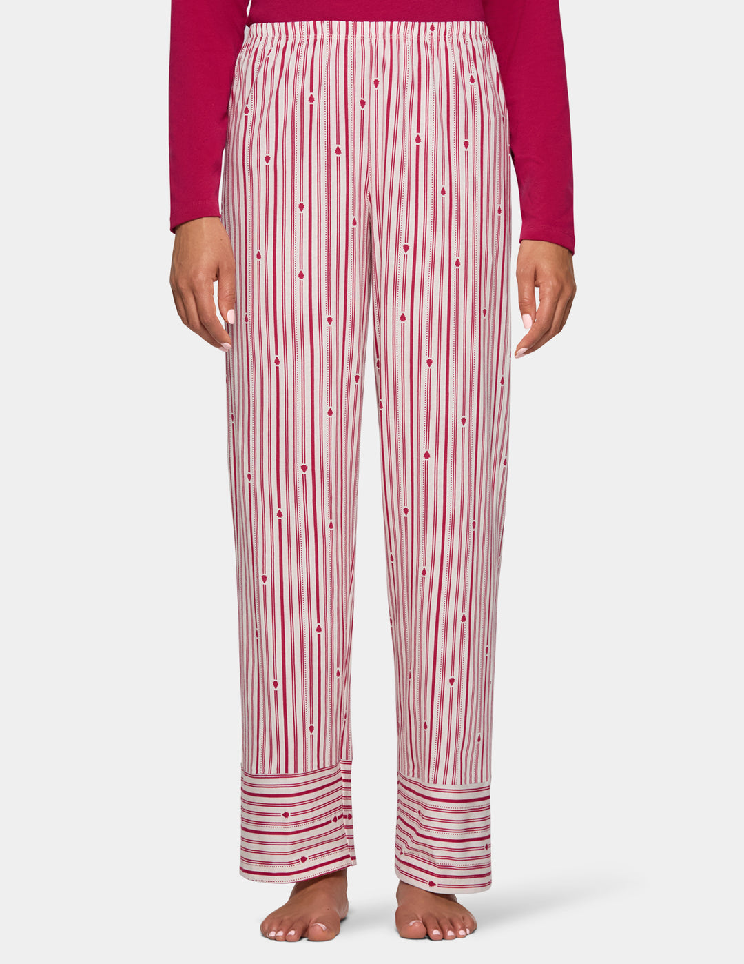 A model wearing long stripe pajama pants and a long sleeve pink pj top.