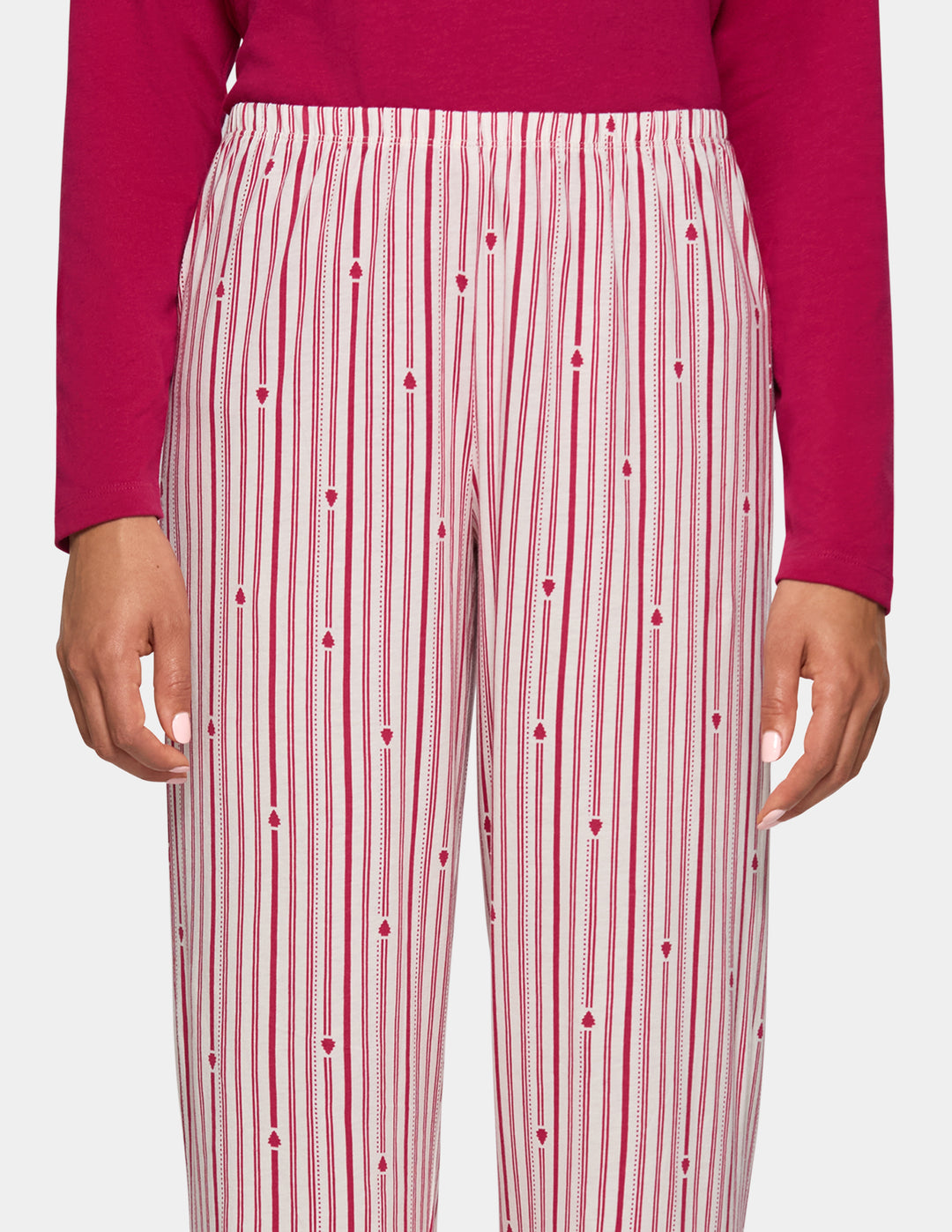 A model wearing long stripe pajama pants and a long sleeve pink pj top.
