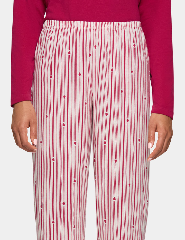 A model wearing long stripe pajama pants and a long sleeve pink pj top.