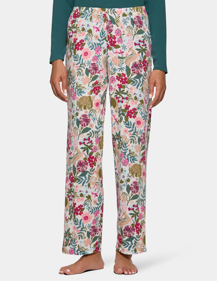 A model wearing long floral print pajama pants and a long sleeve green pajama top.