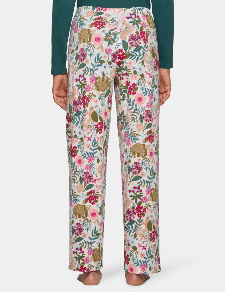 Back view of a model wearing long floral print pajama pants and a long sleeve green pajama top.