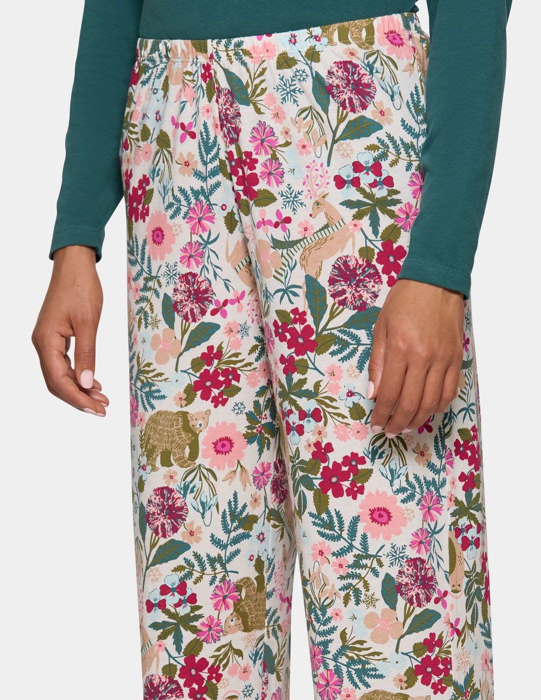 A model wearing long floral print pajama pants and a long sleeve green pajama top.