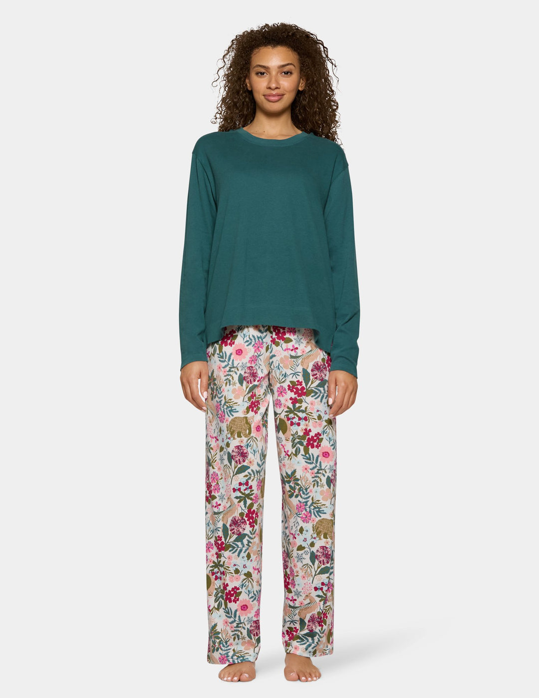 A model wearing long floral print pajama pants and a long sleeve green pajama top.