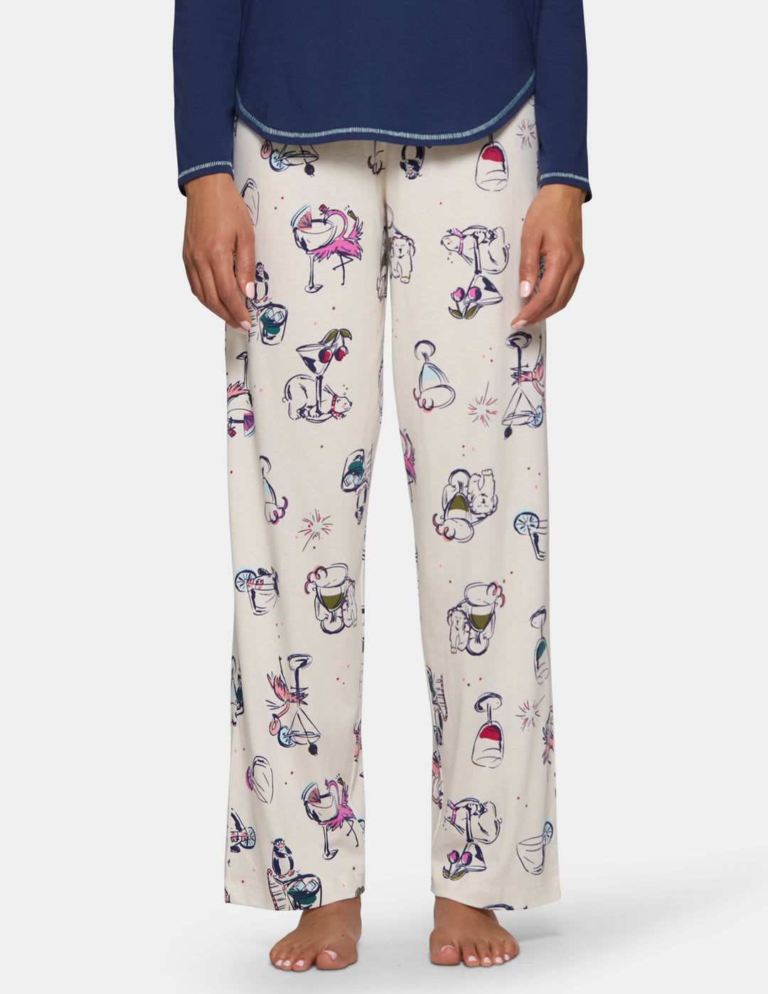A model wearing off-white pajama pants featuring an animal print design, pair with a long sleeve blue top.