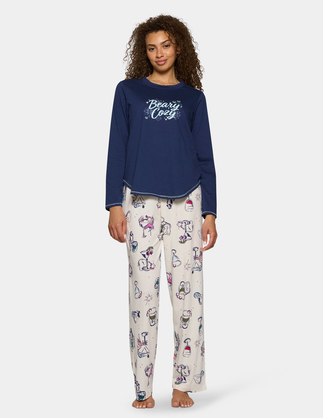 A model wearing off-white pajama pants featuring an animal print design, pair with a long sleeve blue top.