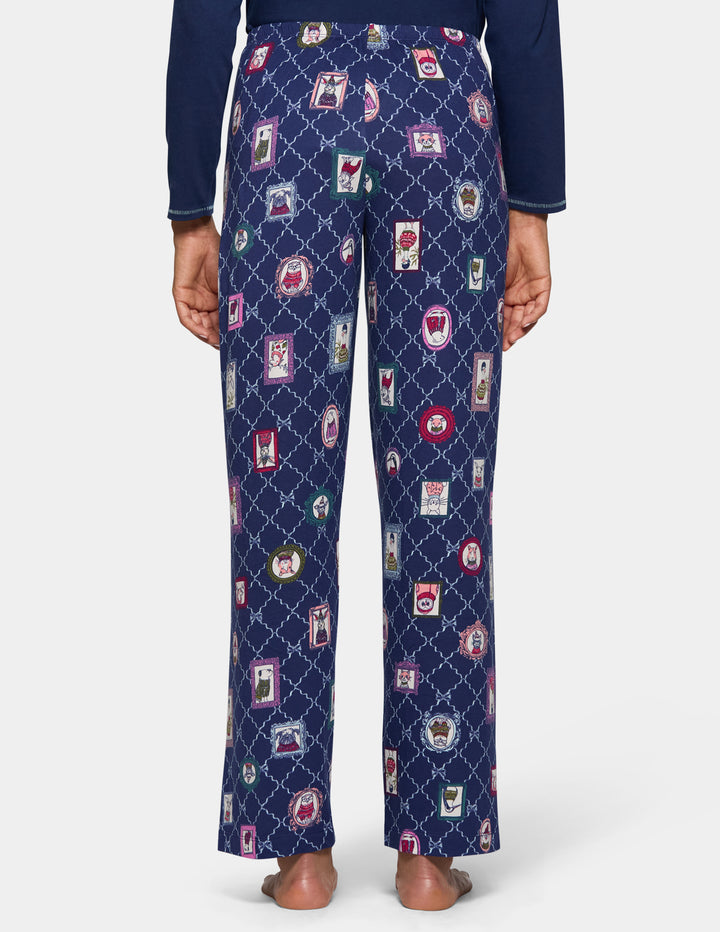 A model wearing navy blue pajama pants with an animal pattern and a long sleeve navy shirt.