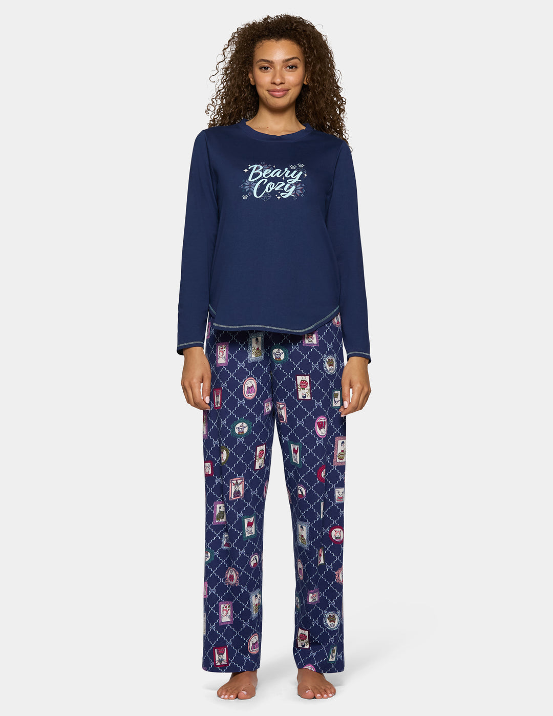 A model wearing navy blue pajama pants with an animal pattern and a long sleeve navy shirt.