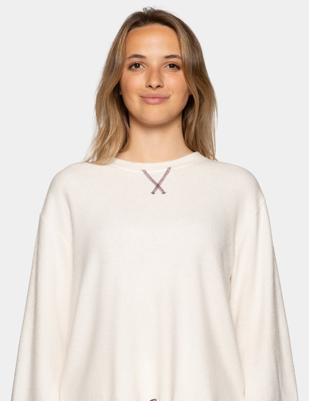 A closeup of a model wearing an off-white long sleeve pajama shirt.