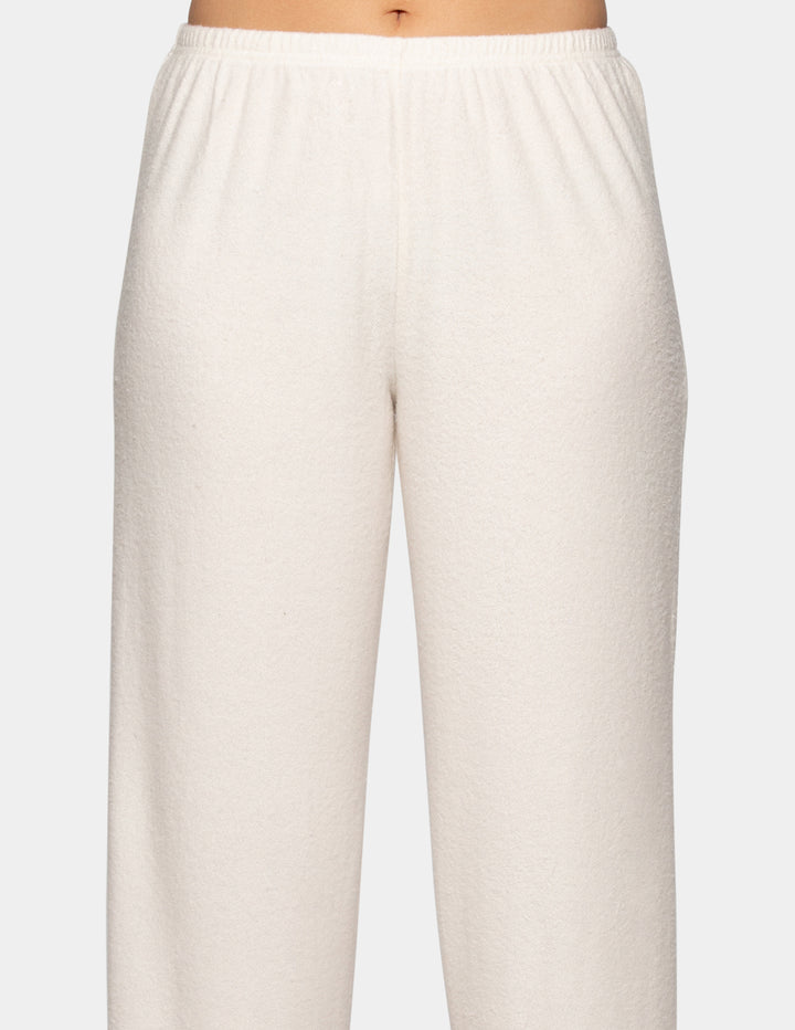 A model wearing a pair of off-white pajama pants.