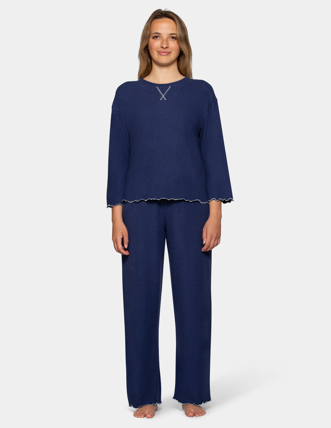A model wearing navy pajama pants and a long sleeve matching shirt.