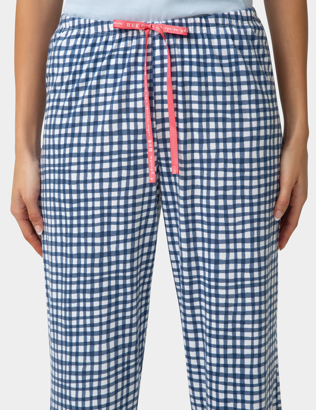Person wearing gingham PJ capri in blue and white check pattern close up