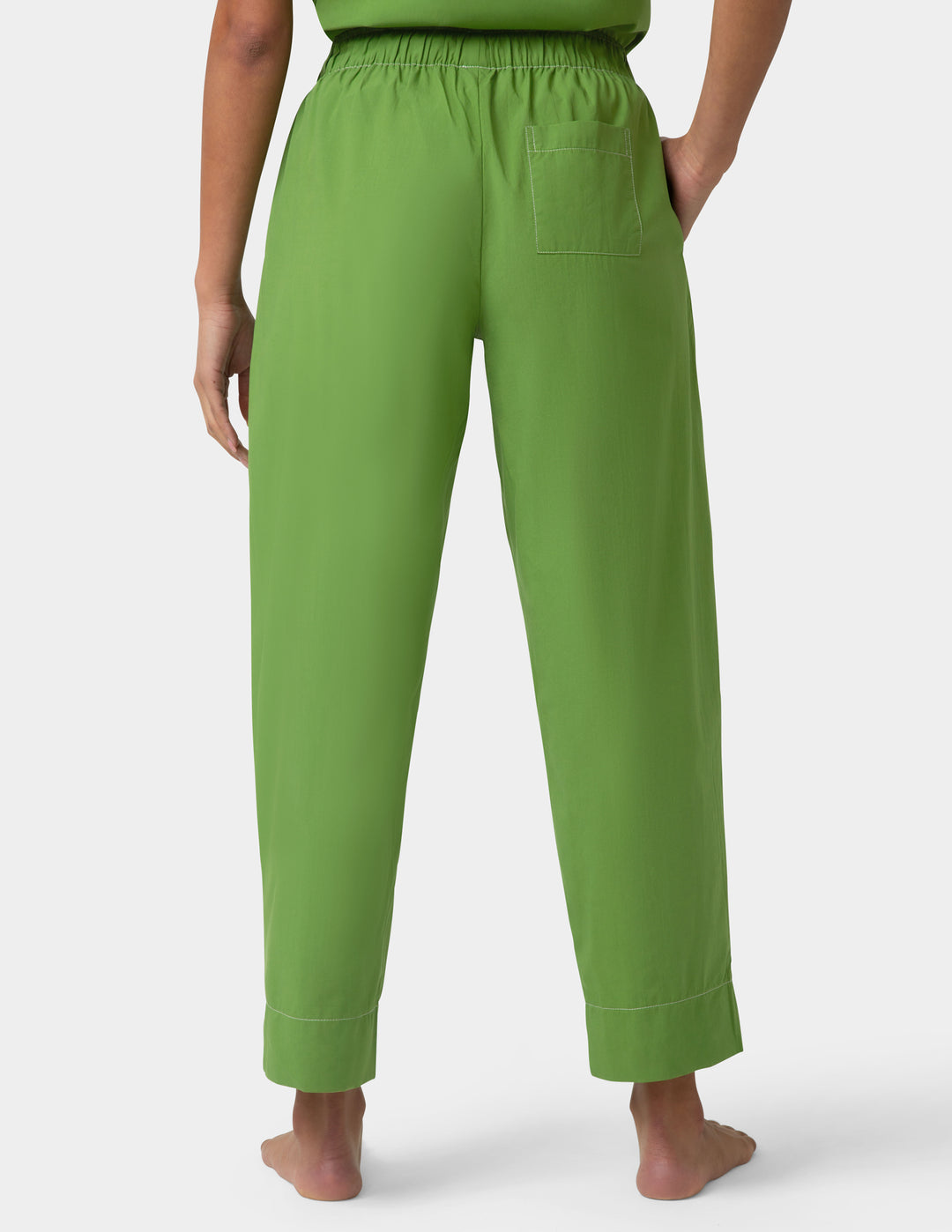 Person wearing green pajama pants back detail