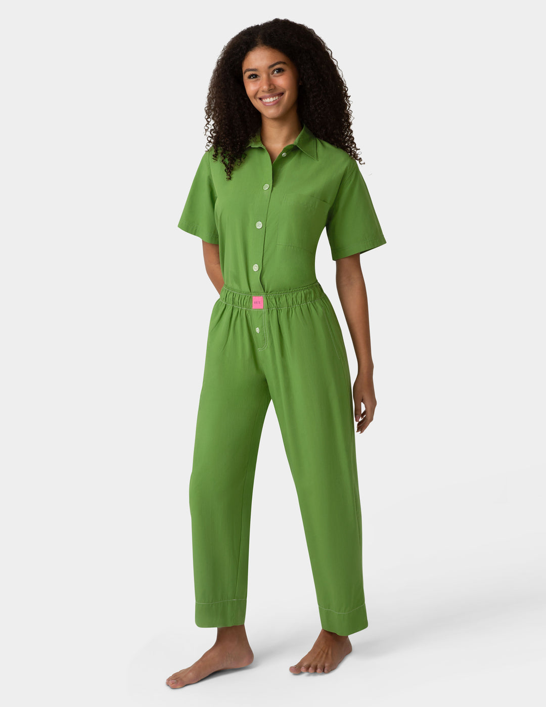 Woman wearing green pajama set on a white background