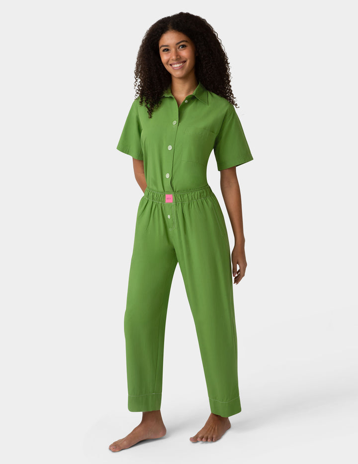 Woman wearing green pajama set on a white background