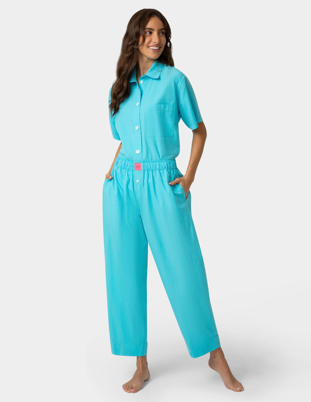 Woman wearing a turquoise pajama set on a white background
