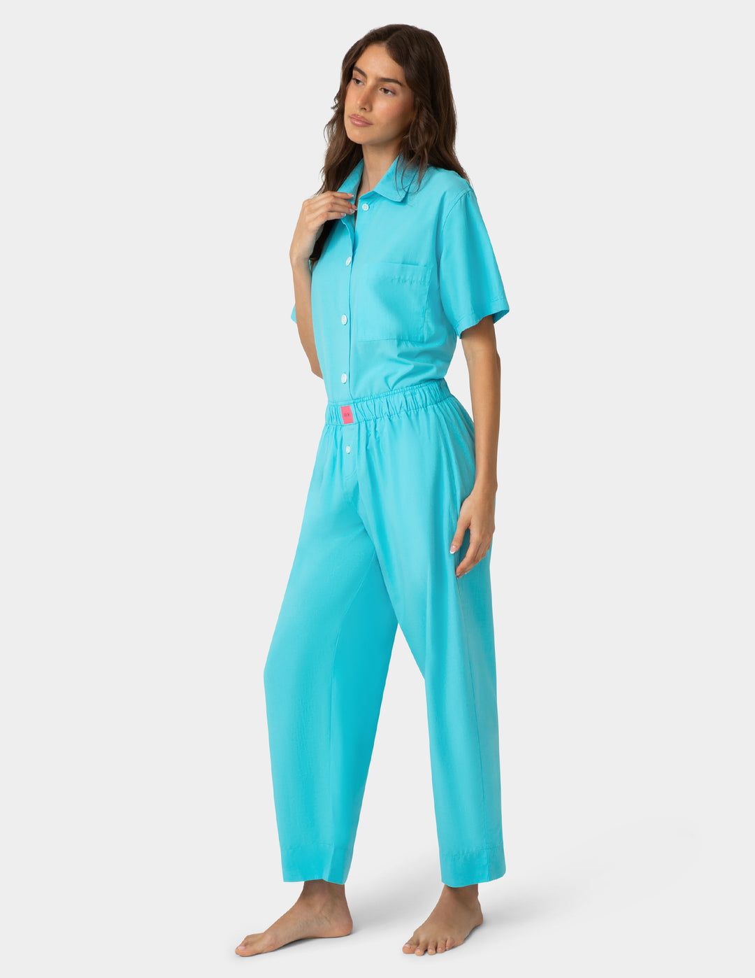 Woman wearing a turquoise pajama set on a white background