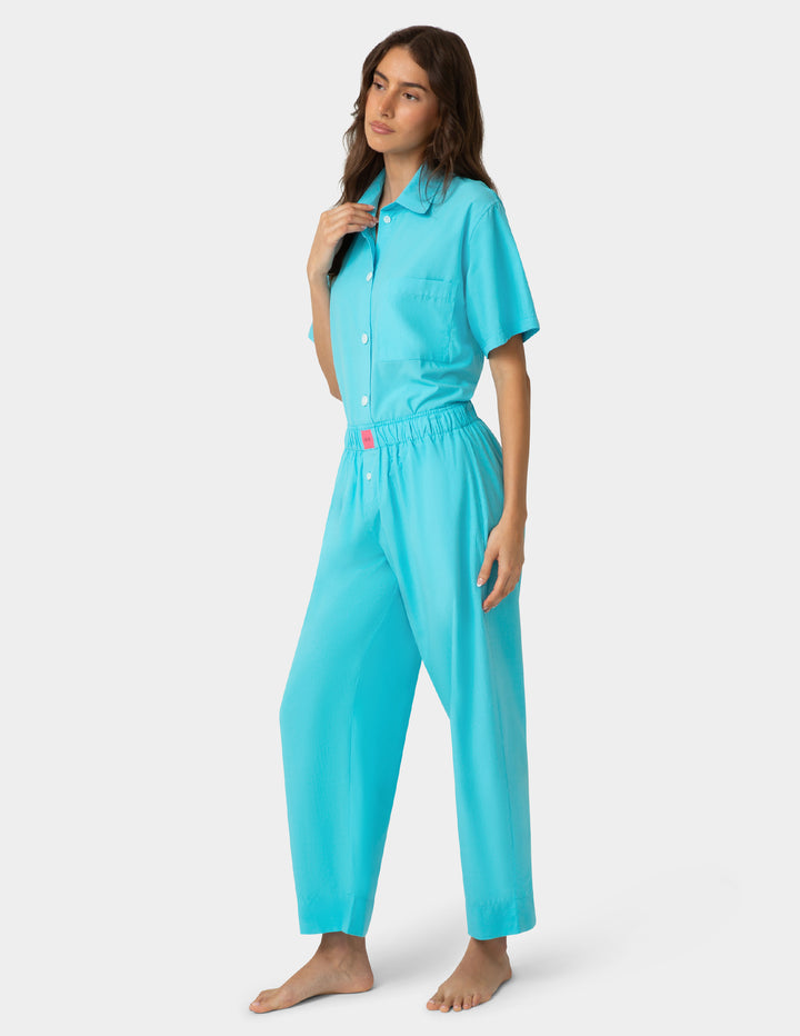Woman wearing a turquoise pajama set on a white background