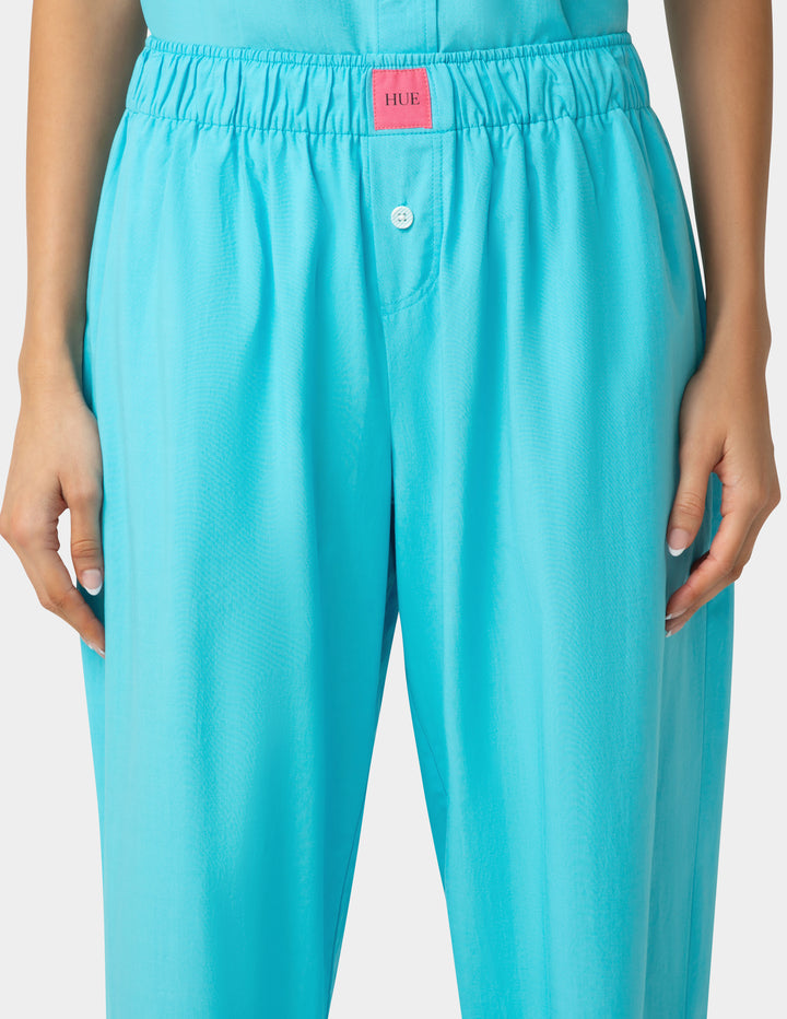 Turquoise pants with a HUE brand logo on a plain background