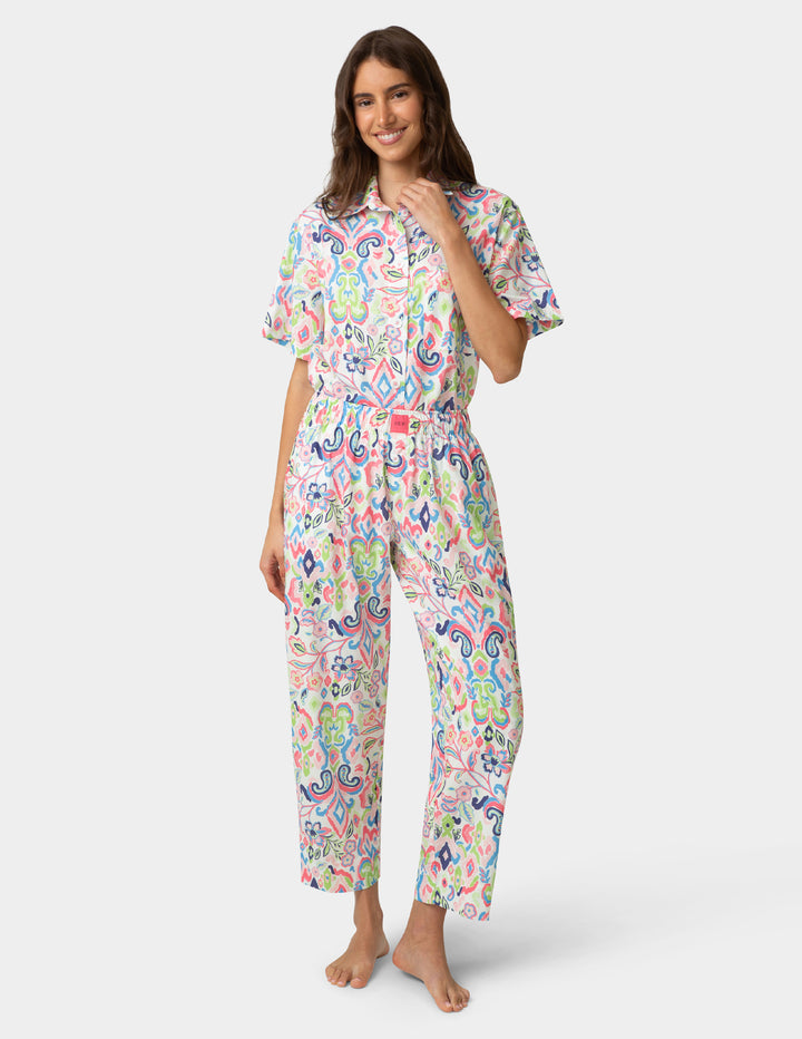 Woman wearing a colorful pajama set on a white background